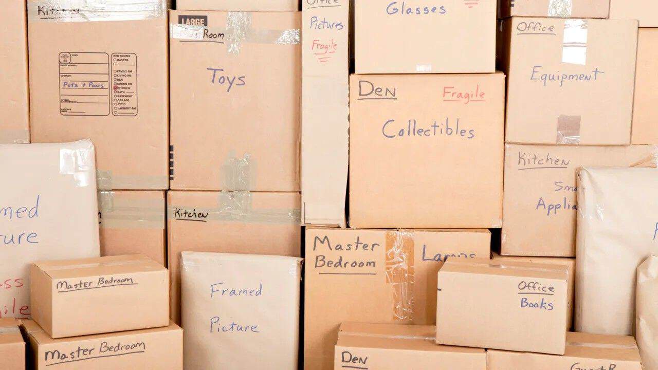 Labeled moving boxes organized by room for easier unpacking